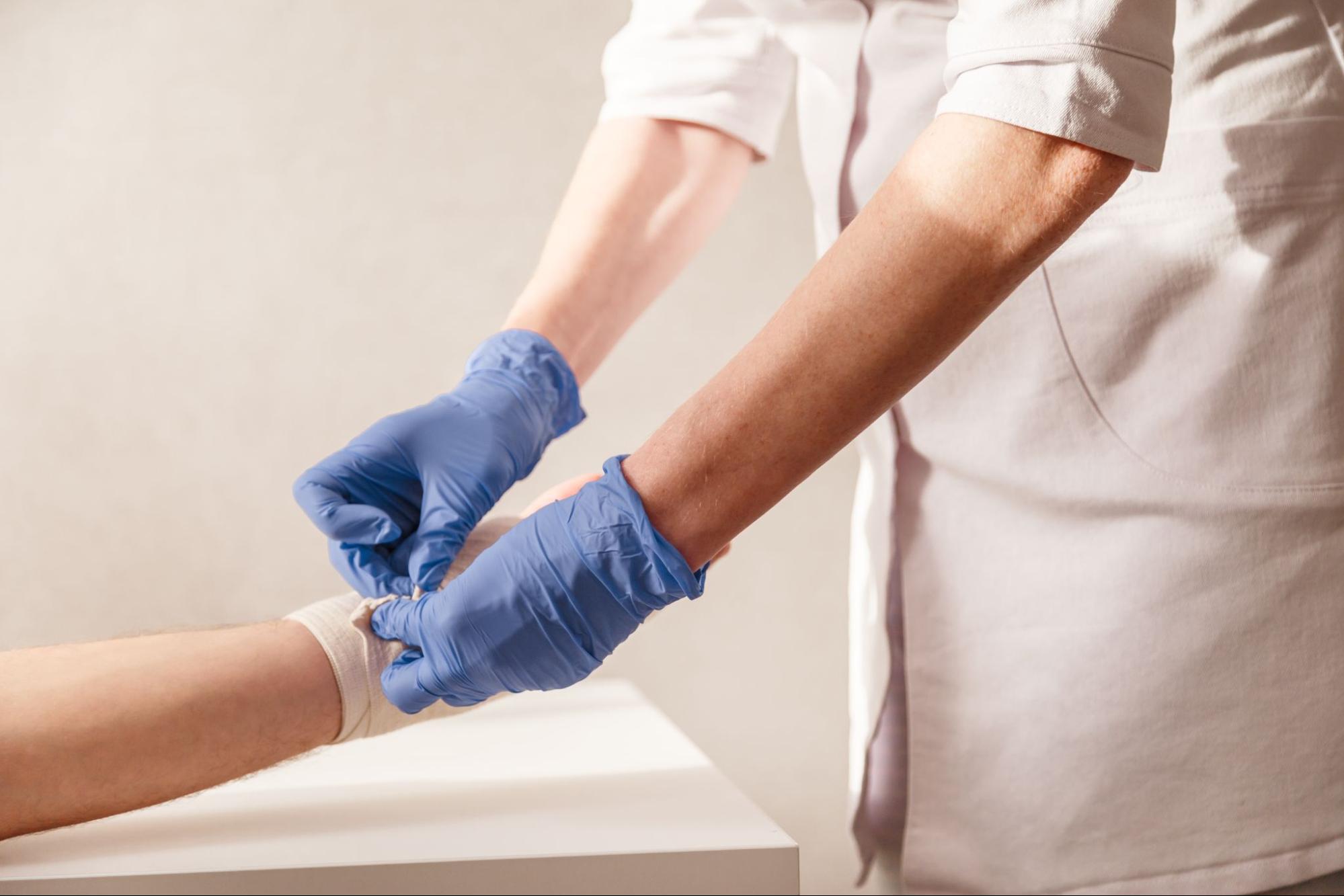 A doctor bandaging a patient’s arm.