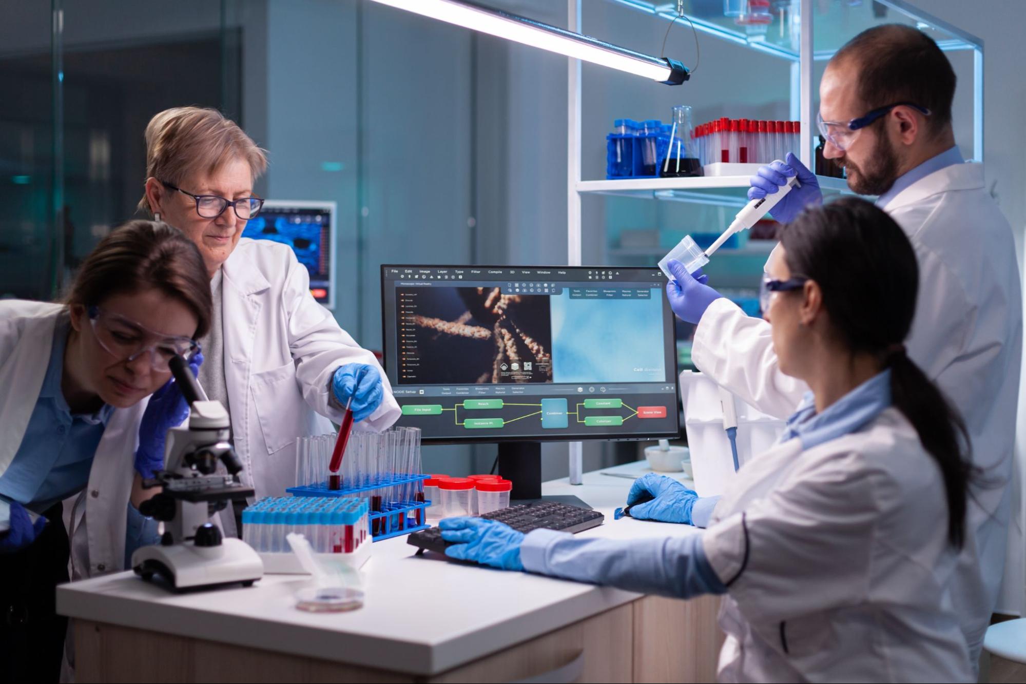A team of four scientists in white coats and latex gloves studying stem cells in a lab. This image is a concept of where stem cells are found.