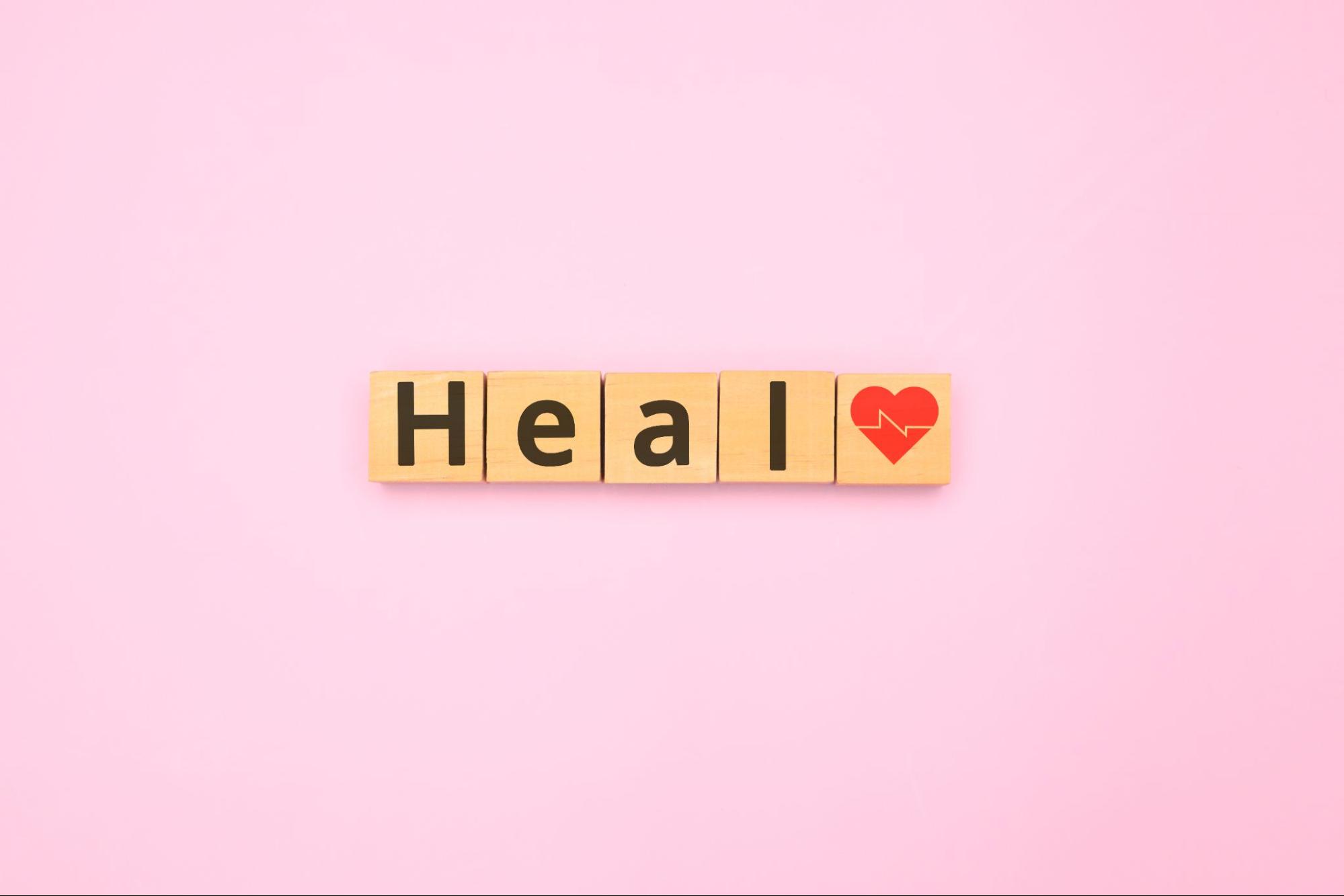 Wooden blocks that have the word “Heal” spelled out next to a medial heart symbol. This is a concept for the process of wound healing.