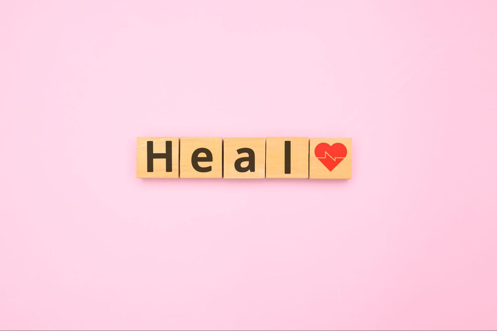 Scrabble-like letters spelling out the word “heal” next to a heart.