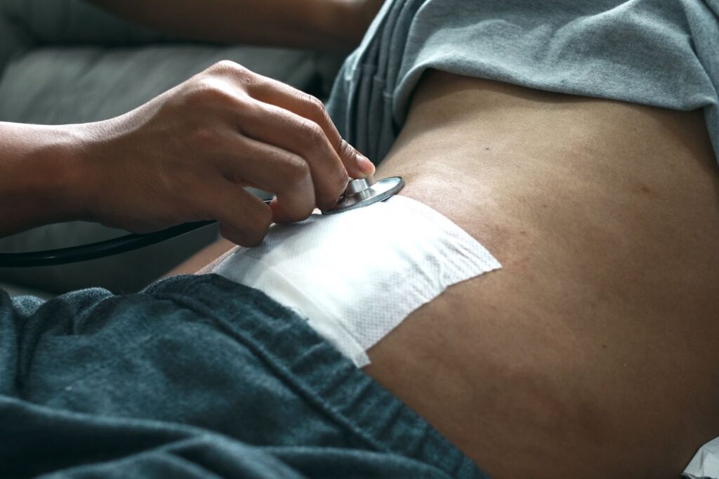 Surgeon checking postoperative abdominal wound treated with an amniotic graft.